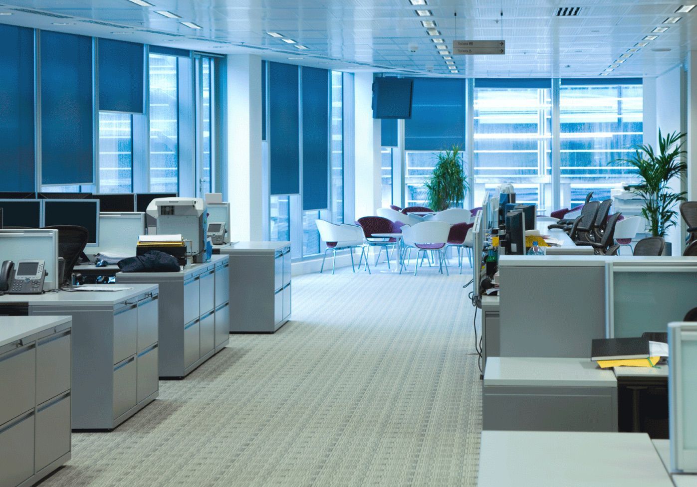 An empty office with a lot of windows and cubicles