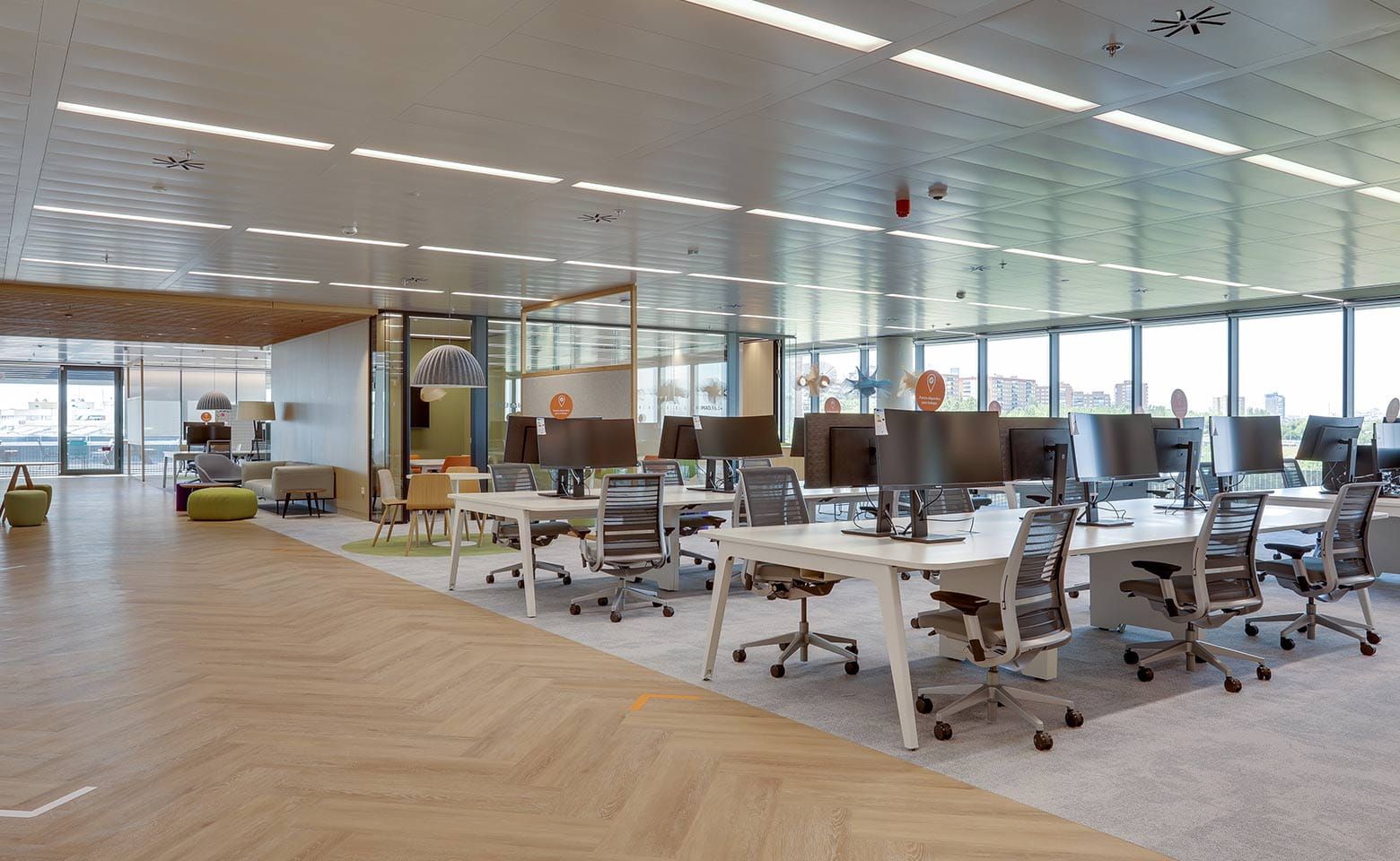 A large empty office with lots of desks and chairs.