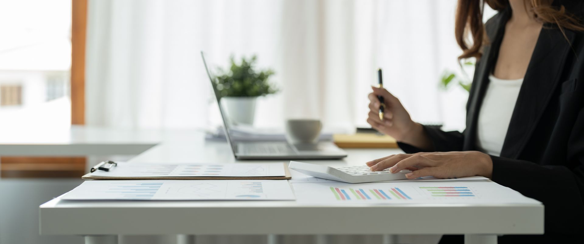 Close-up view of a bookkeeper’s hands making a report, calculating, or checking a balance.