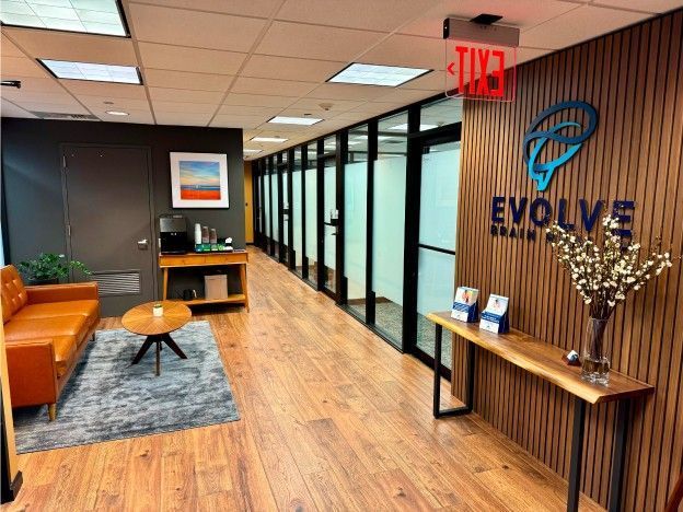 A woman is sitting in a chair with a helmet on her head.