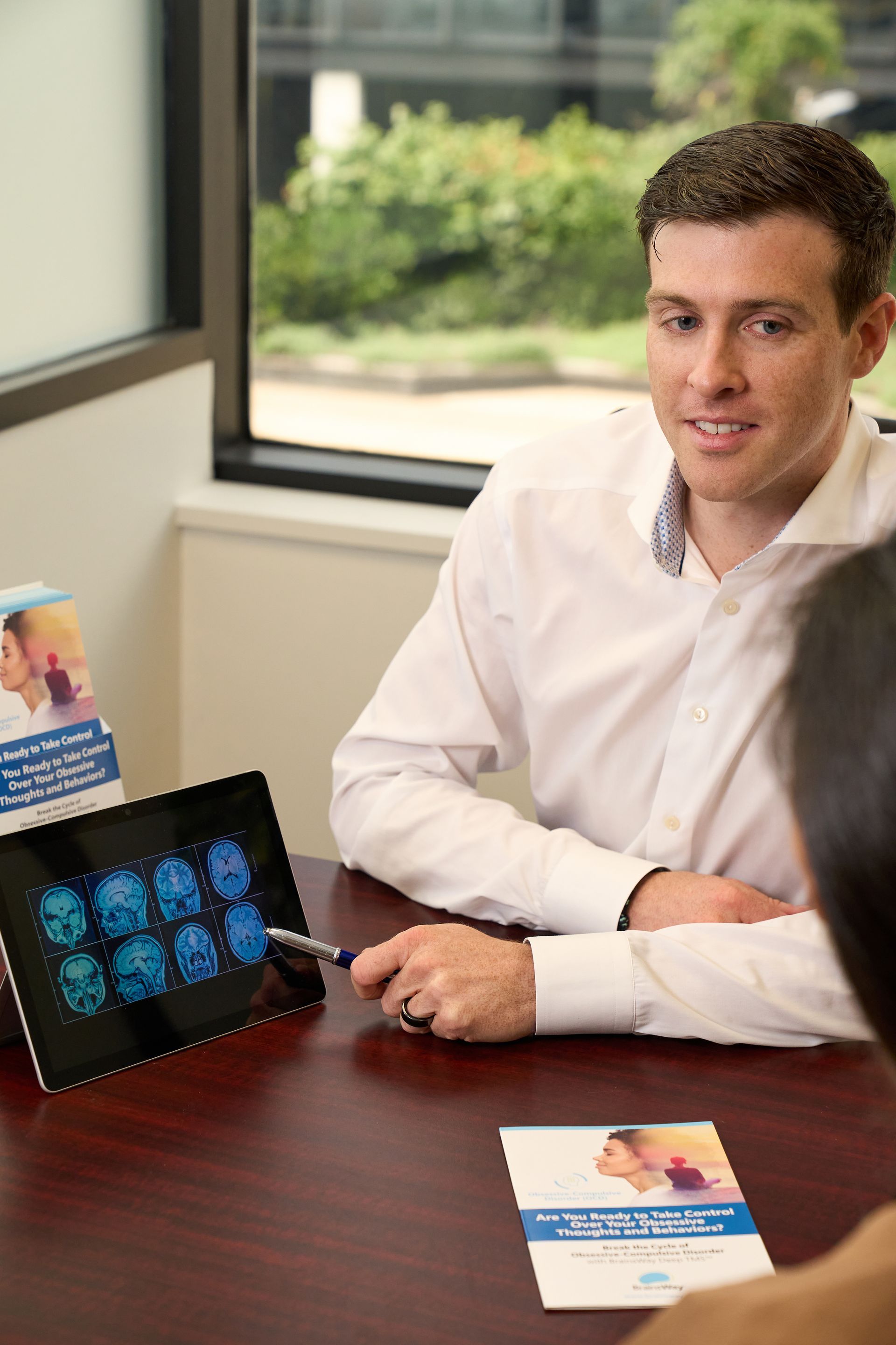 A man is sitting at a table talking to a woman.