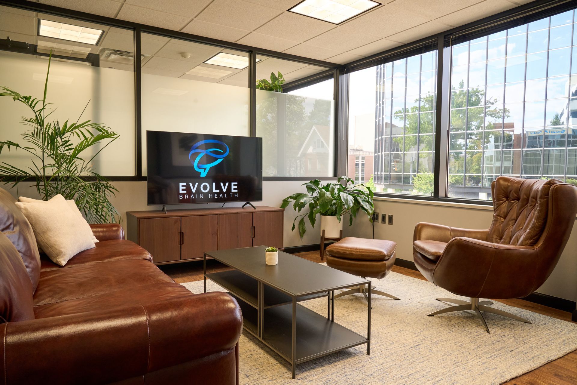 A living room with a couch , chair , coffee table and television.