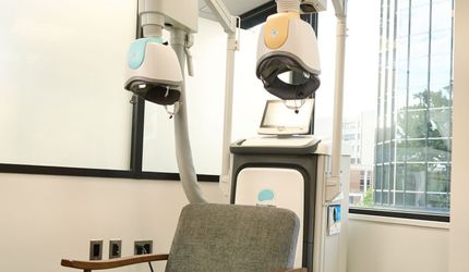 A chair is sitting in front of a machine in a room.