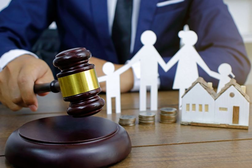 Un giudice tiene un martelletto davanti a una famiglia e a una casa.