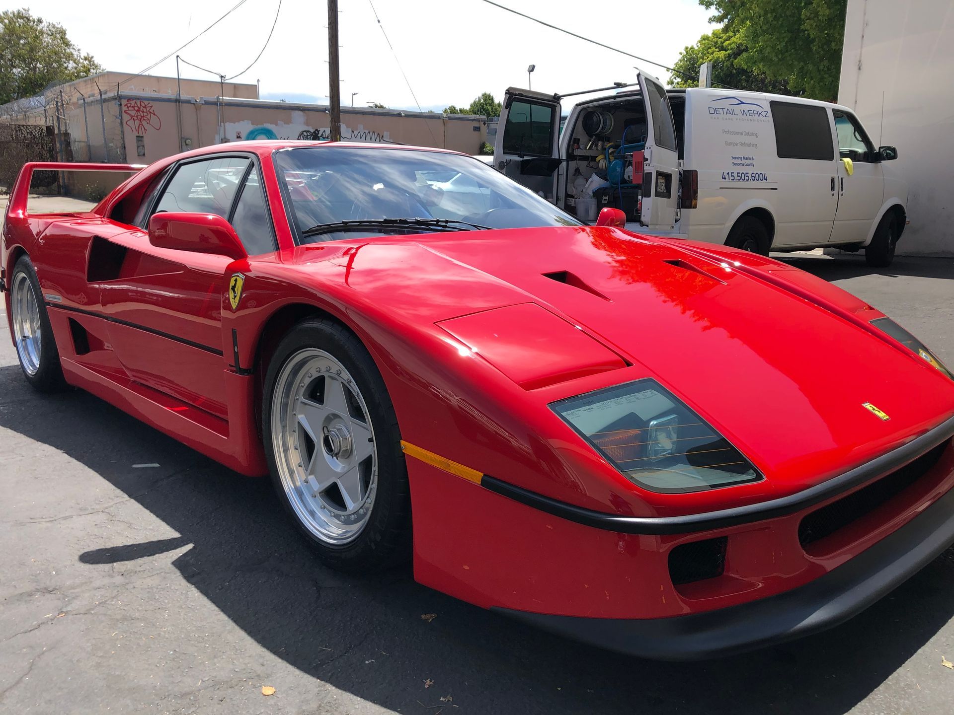 Person vacuuming the interior of a car. Close-up on the black seat, vacuum nozzle pointed down.