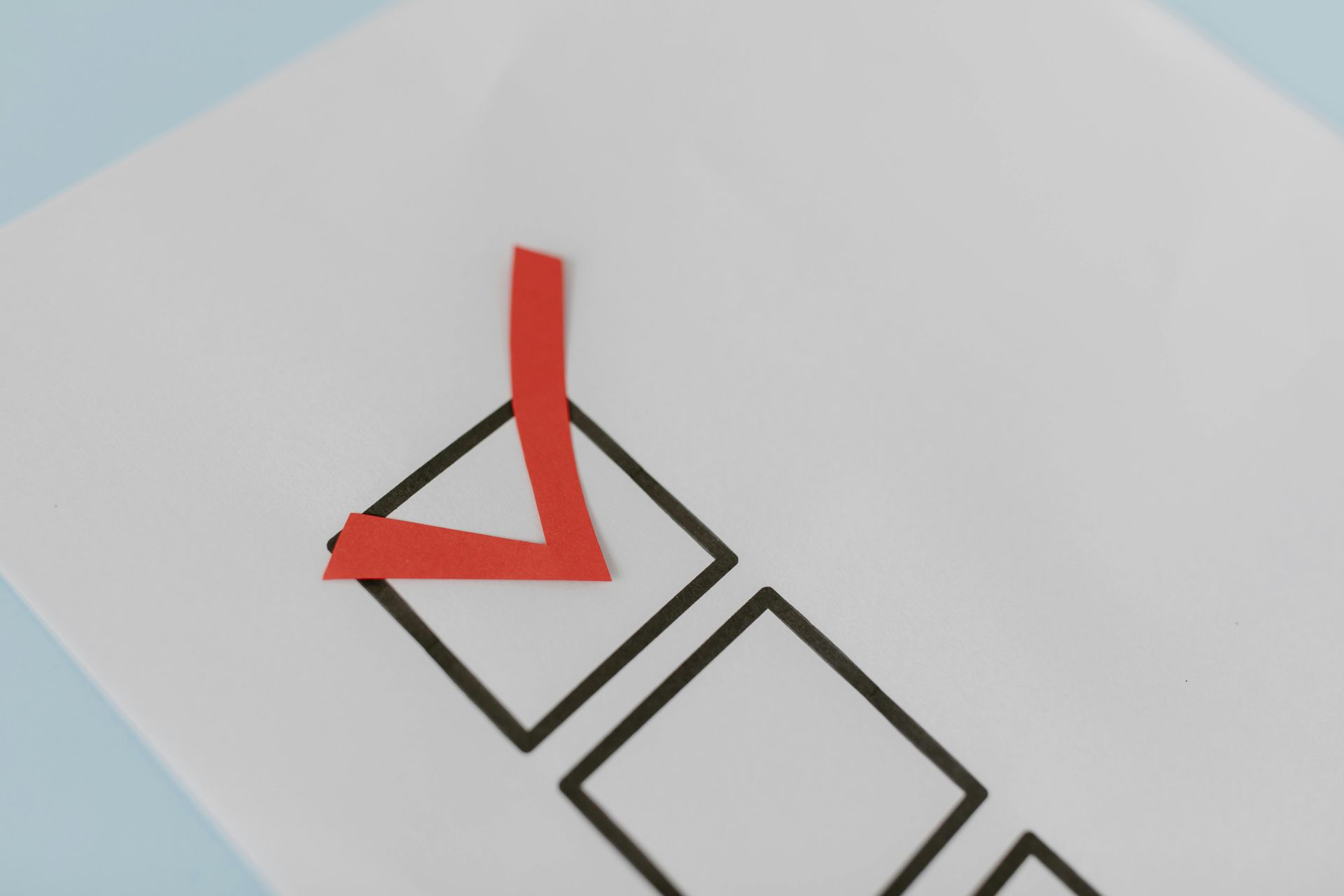 Red check mark drawn on a white page with outlined squares.
