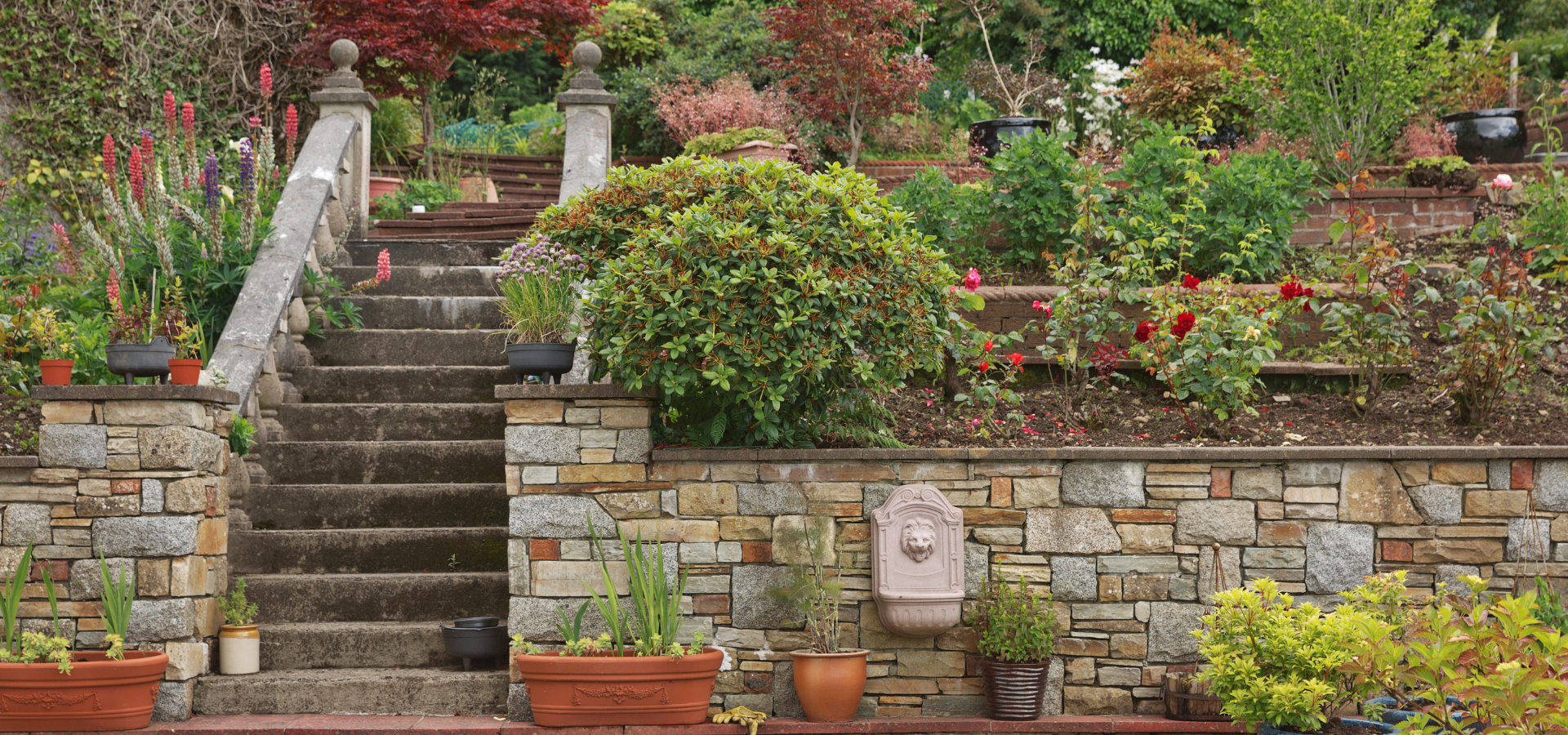 The entrance of a home with retaining walls and stone steps, built by Louisville Landscape Pros