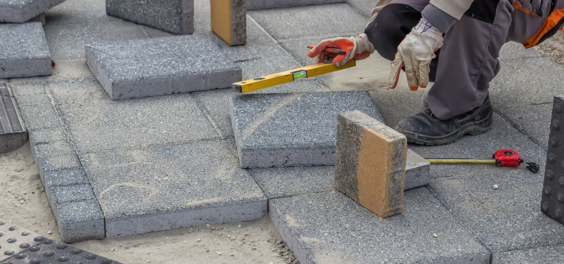 A landscaper installing brick pavers for a client in Louisville