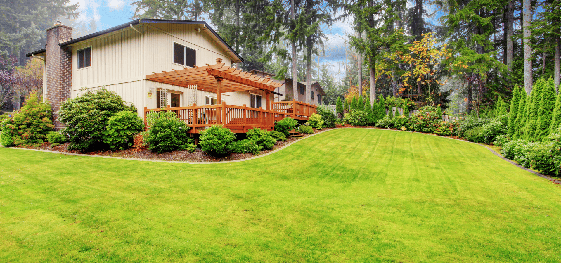 A large backyard in Louisville, KY, with a pergola and deck
