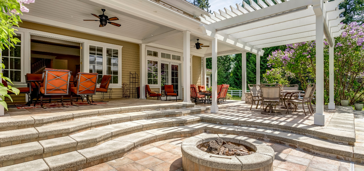 Outdoor space with a white pergola and a fire pit