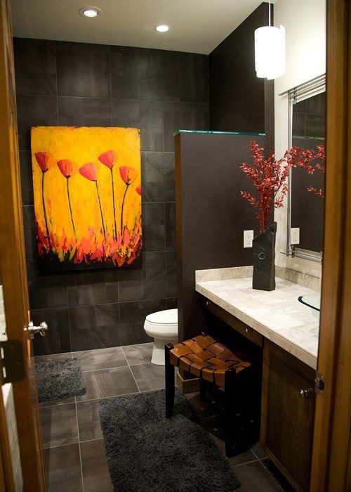 A bathroom with a painting on the wall above the toilet