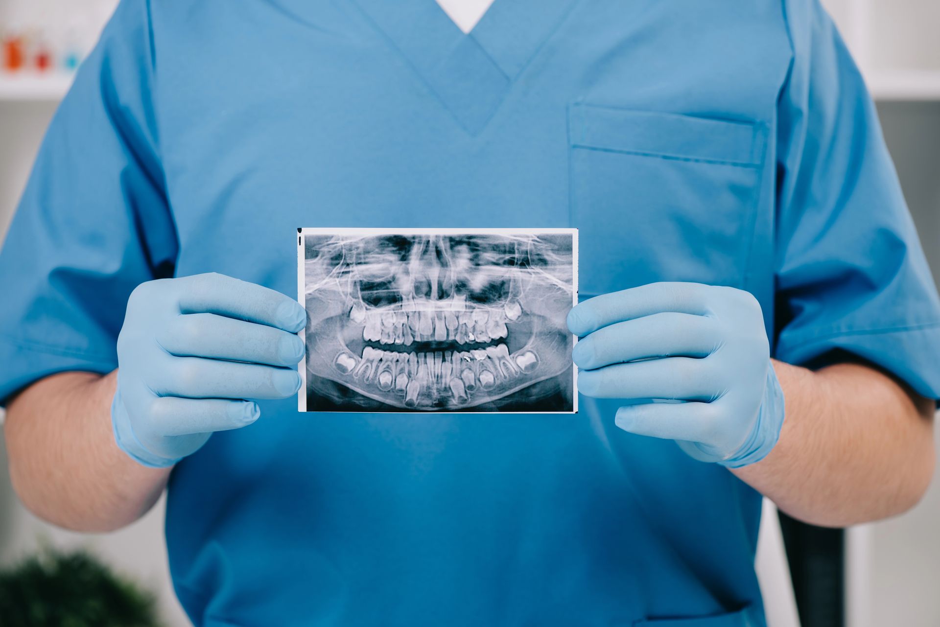 Un dentista sostiene una radiografía de los dientes de un paciente.