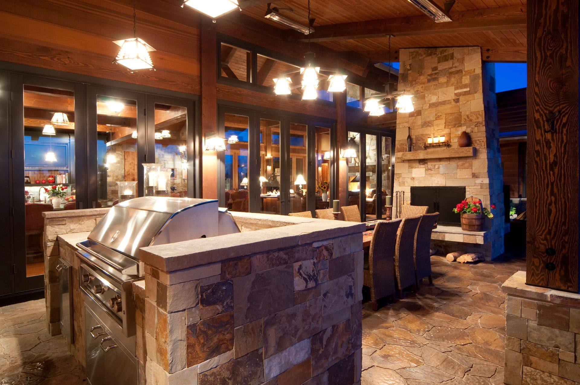 A large outdoor kitchen with a grill and a fireplace
