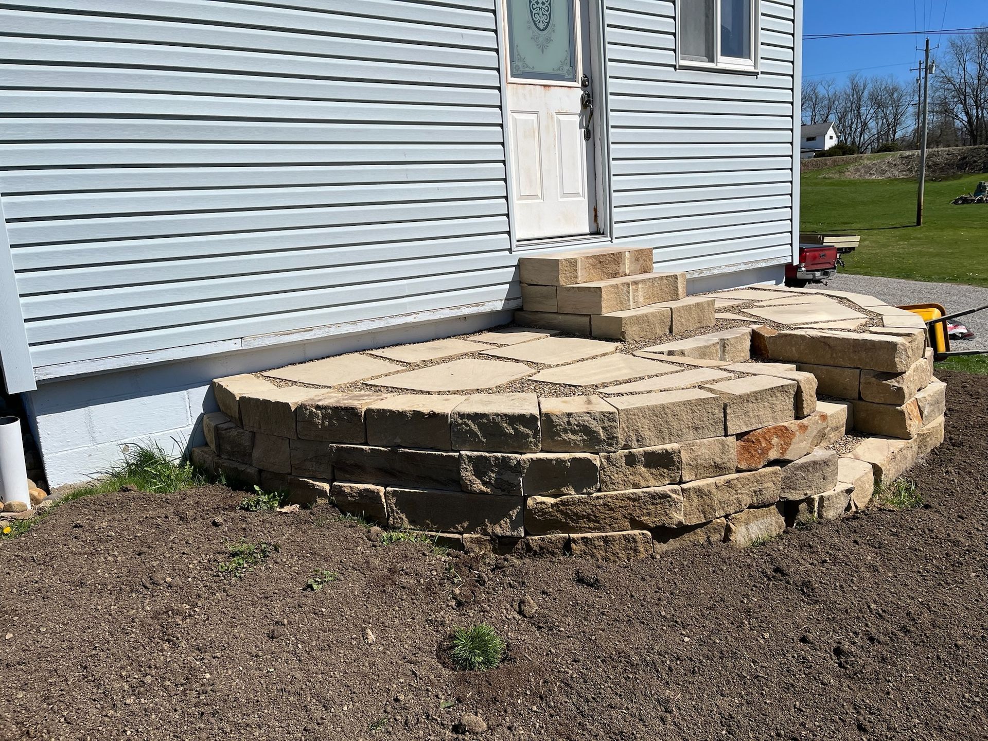 A stone staircase is being built in front of a house.