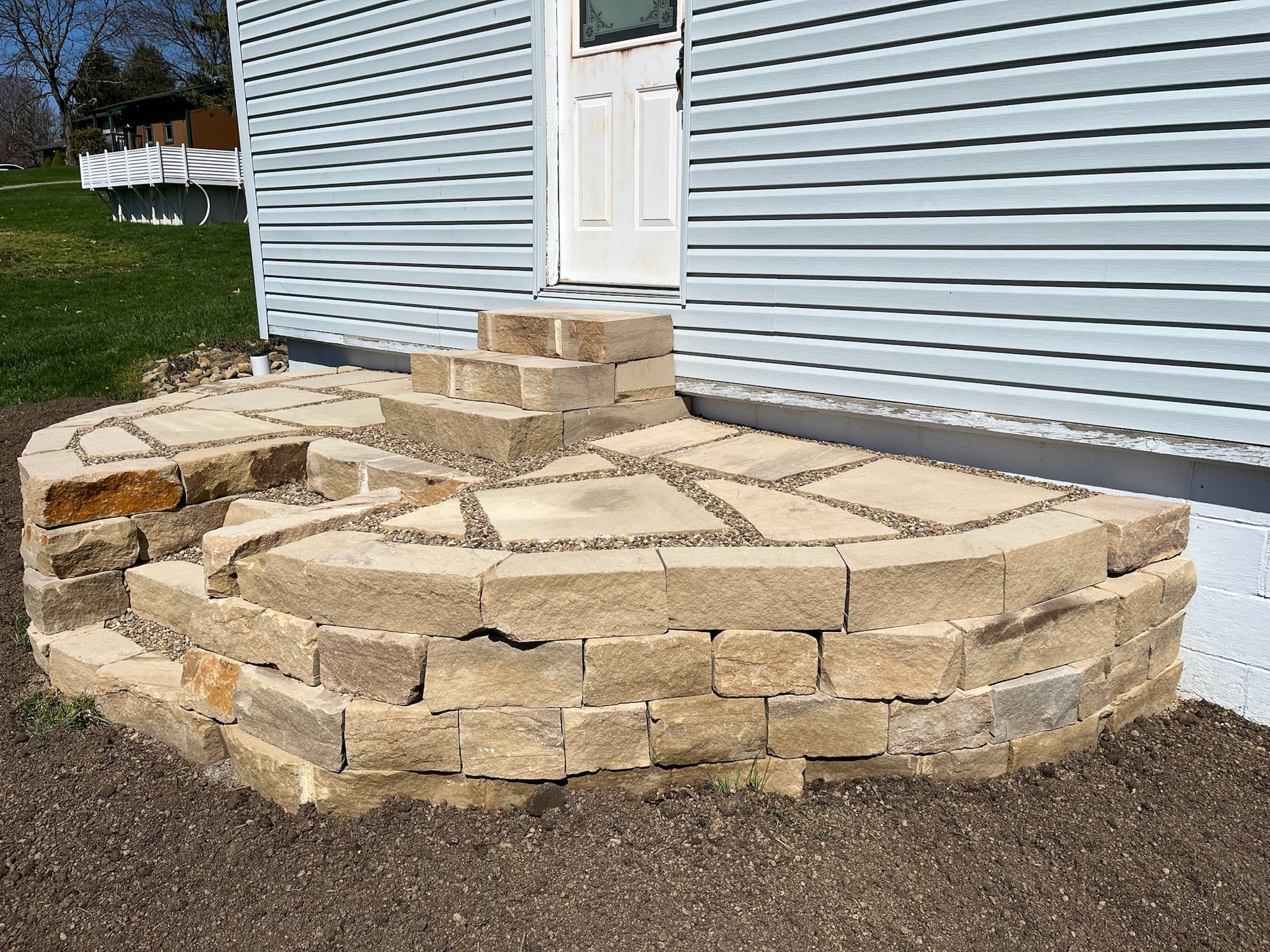 A stone staircase is being built in front of a house.