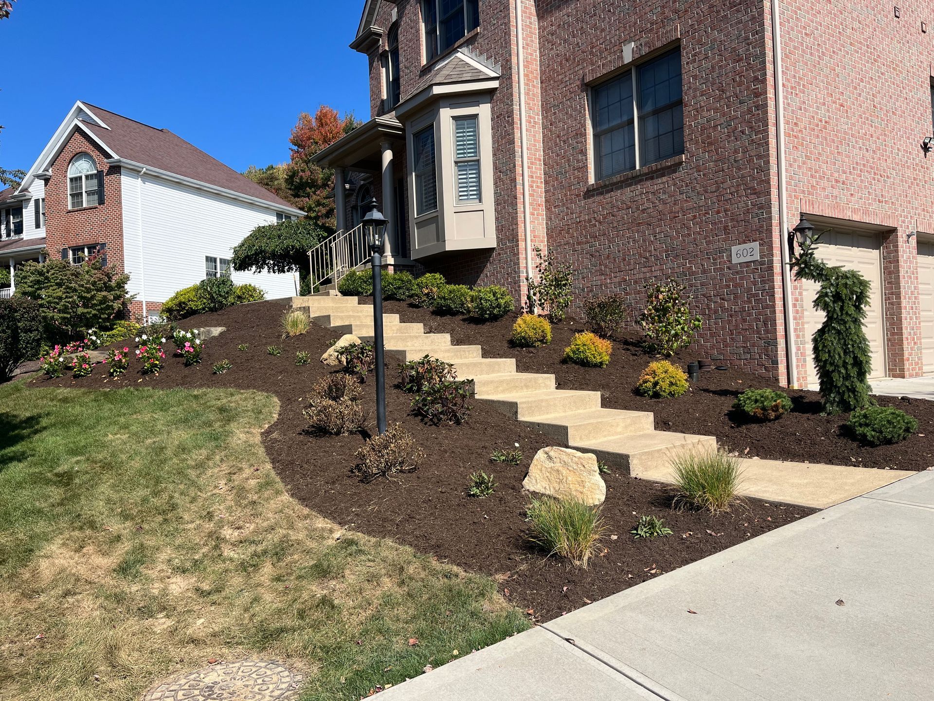 A brick house with stairs leading up to the front door