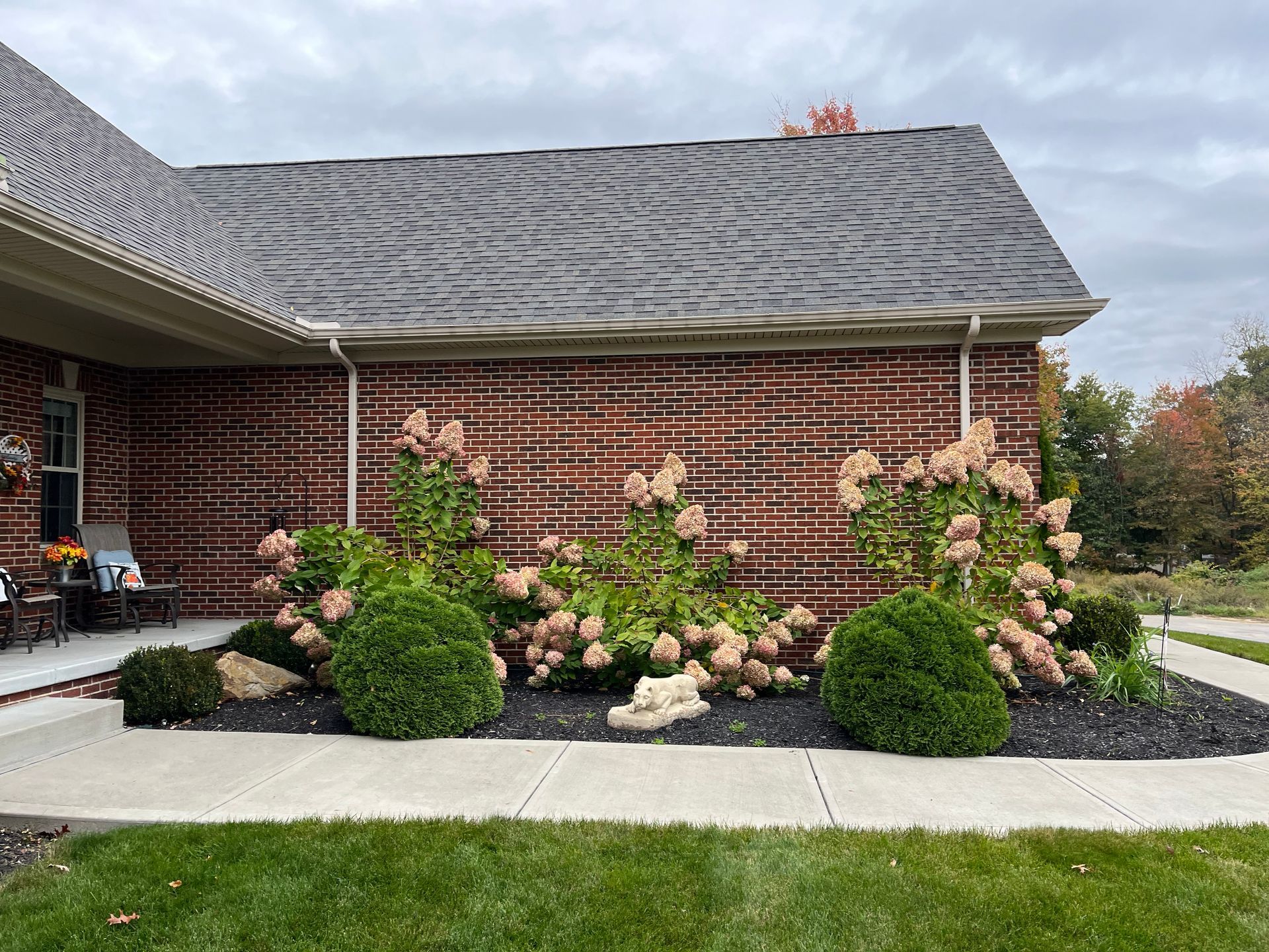 A brick house with a garden in front of it.