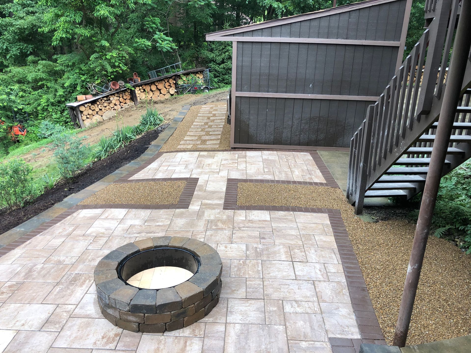 A fire pit is sitting on a patio next to stairs.