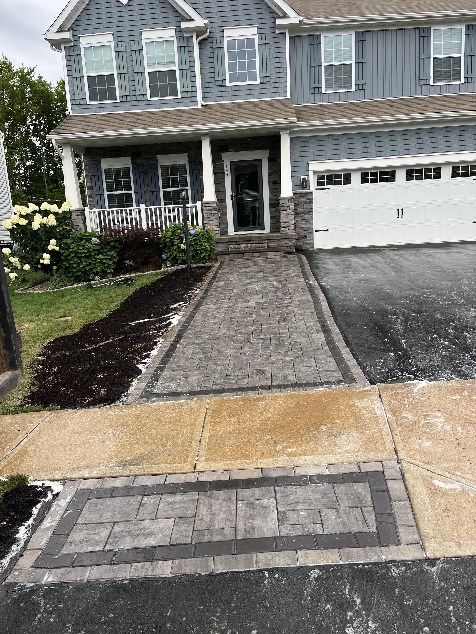 A large house with a brick walkway leading to it