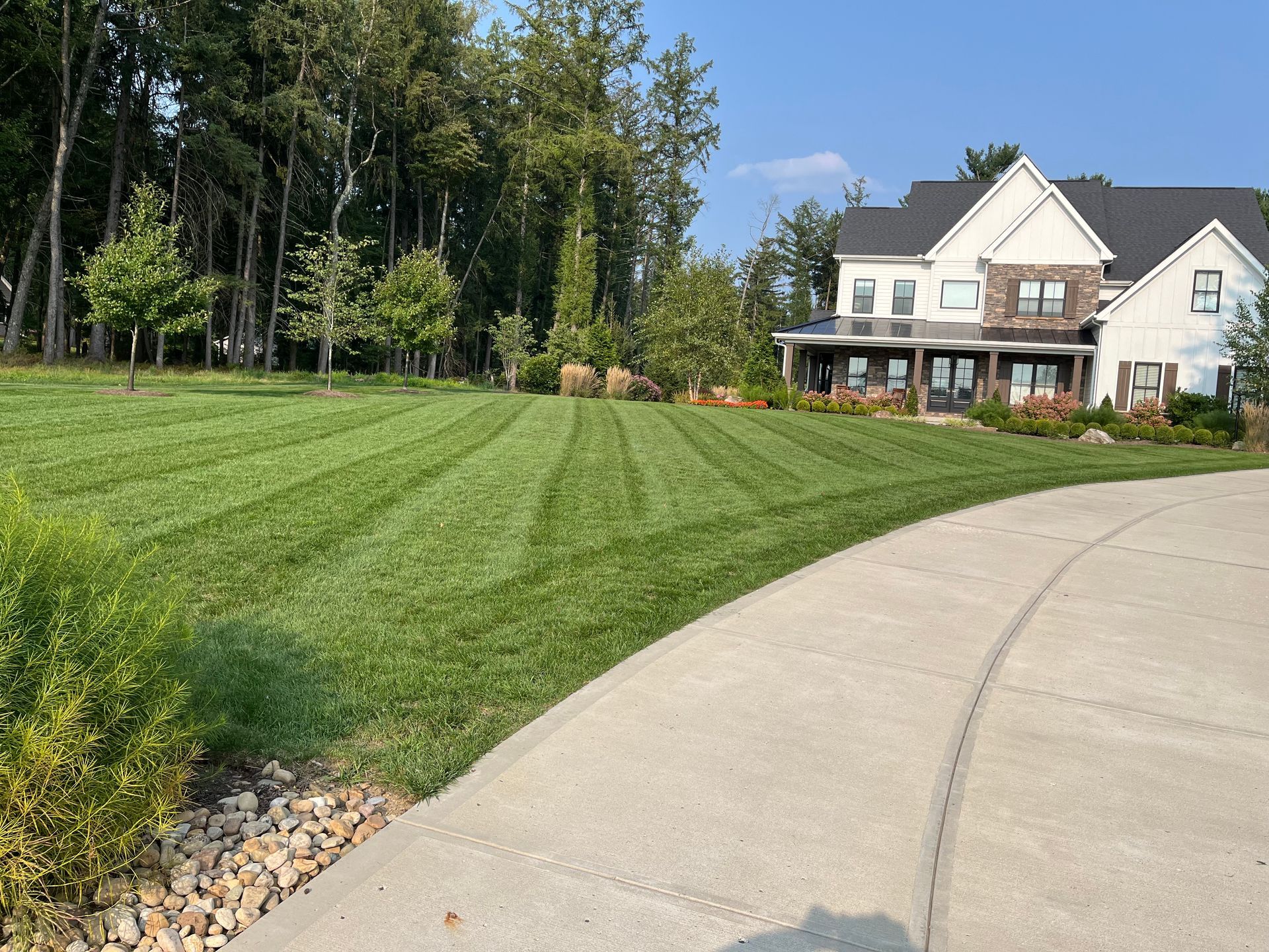 A large white house with a lush green lawn in front of it.