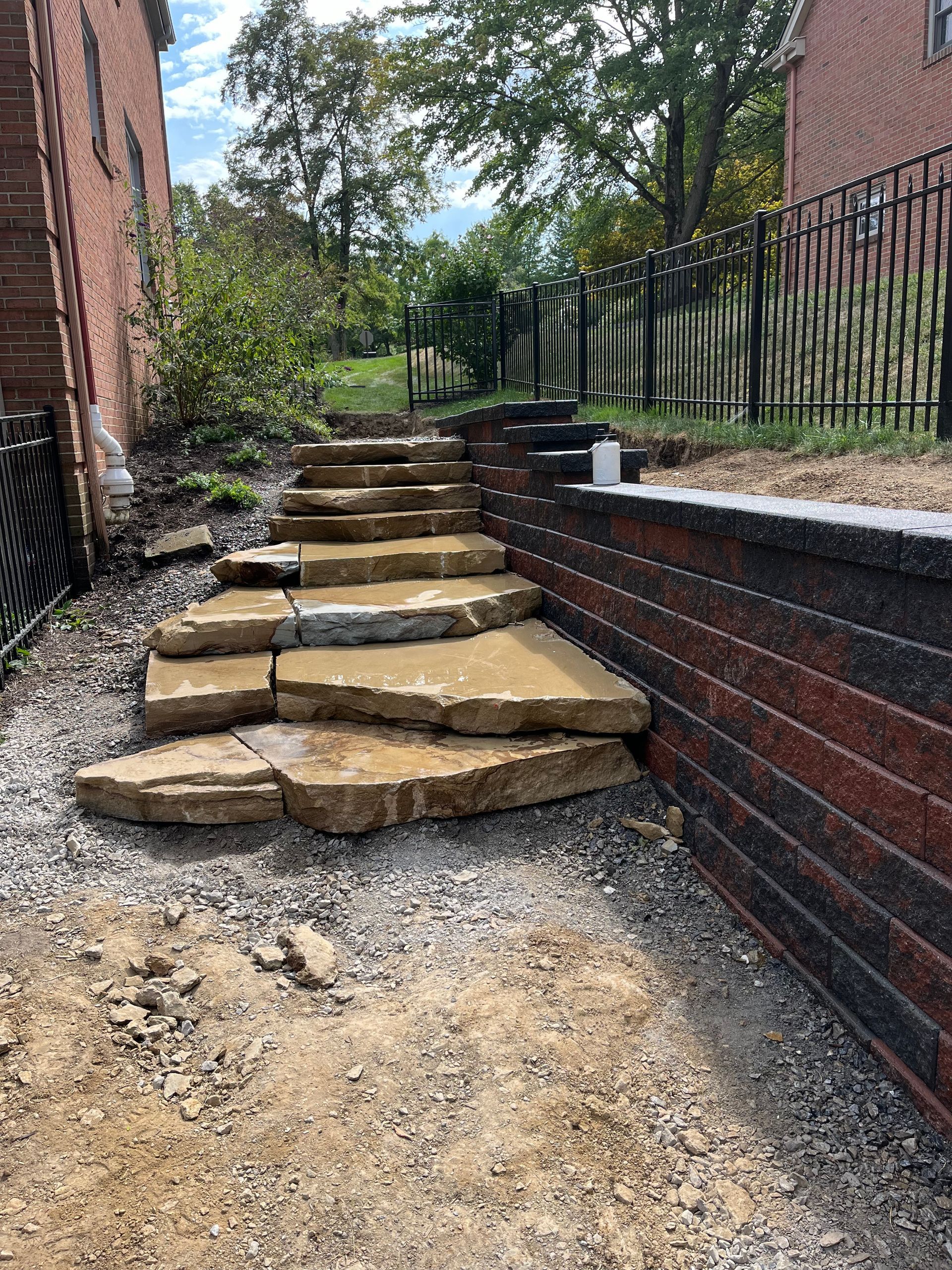 A set of stone steps leading up to a brick wall.