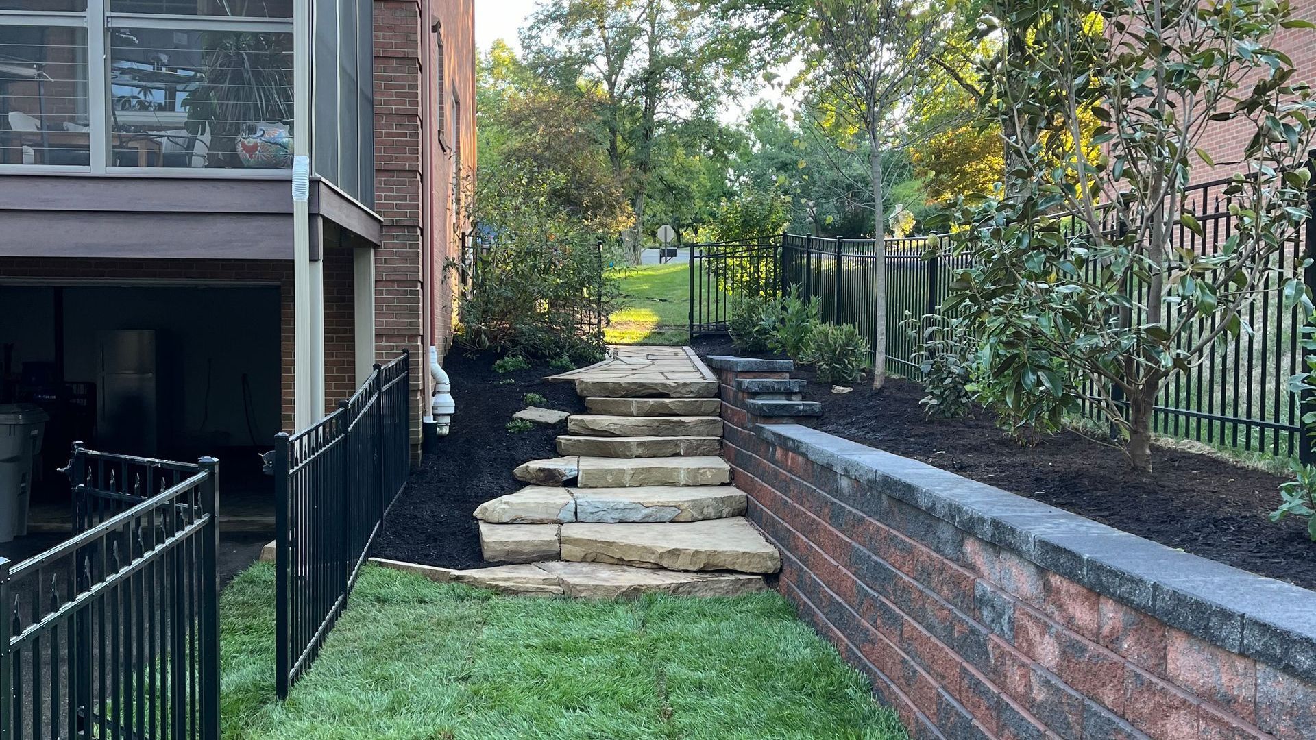 There are stairs leading up to the backyard of a house.