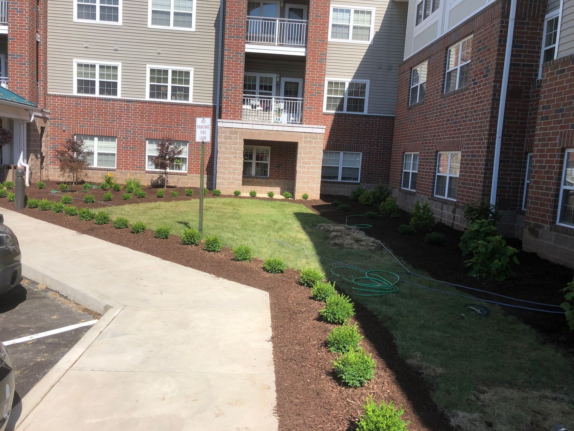 A large apartment building with a lush green lawn in front of it.