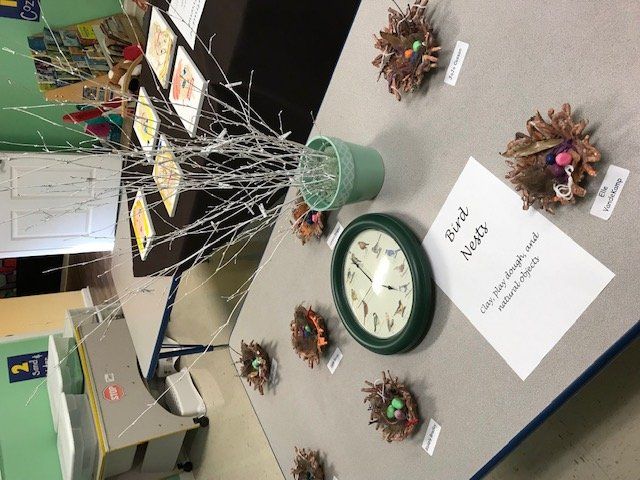 A table with a clock and a sign that says bird nests