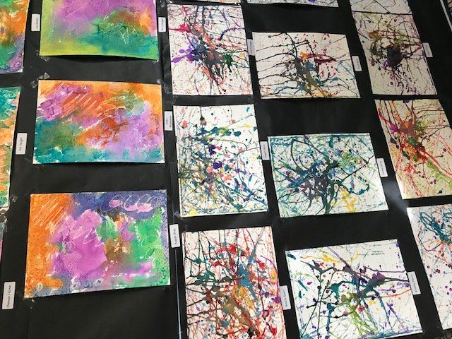 A display of children 's paintings on a black background