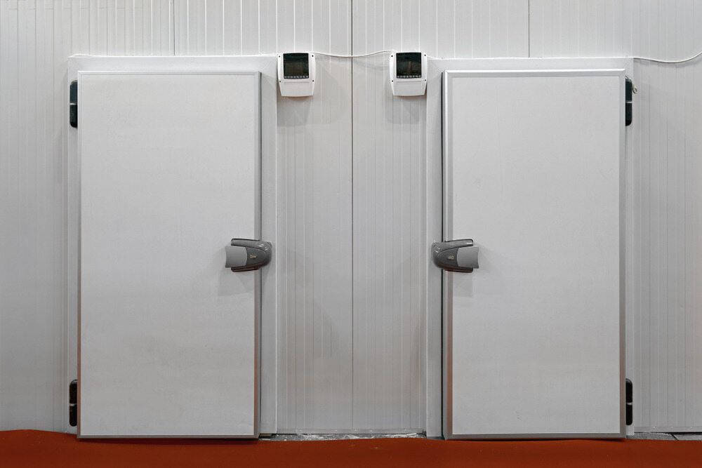 A Couple Of White Doors In A Room With A Red Floor — Jordan Wheatland Air Conditioning & Refrigeration In Parkes, NSW