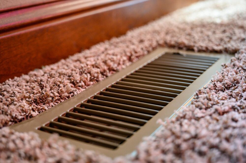 A Close Up Of A Vent On The Floor Next To A Carpet — Jordan Wheatland Air Conditioning & Refrigeration In Dubbo, NSW
