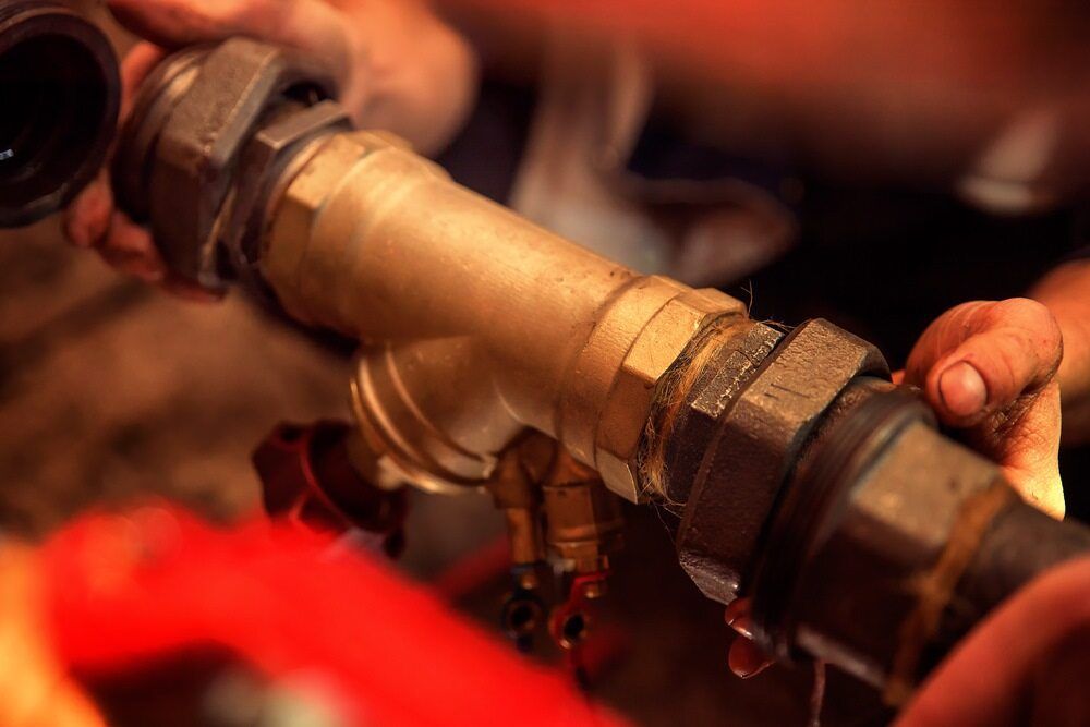 A Close Up Of A Person Fixing A Pipe — Jordan Wheatland Air Conditioning & Refrigeration In Dubbo, NSW