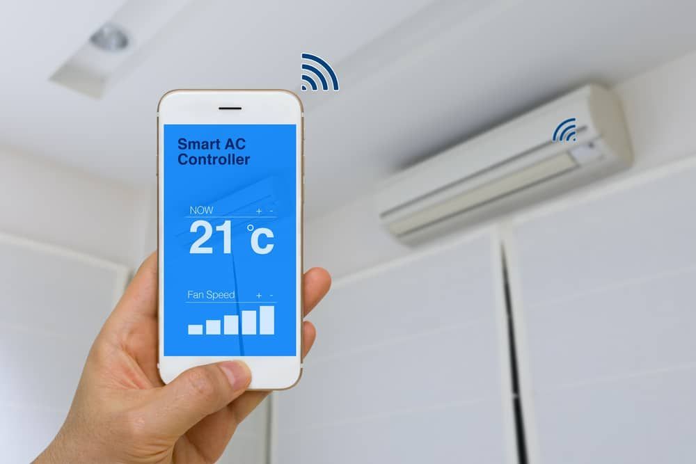 A Person Is Holding A Smart Phone — Jordan Wheatland Air Conditioning & Refrigeration In Dubbo, NSW
