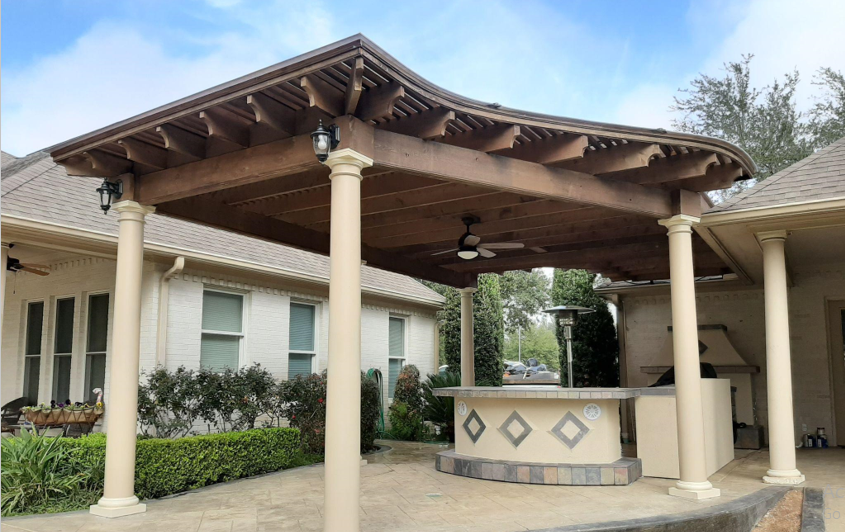 A gazebo with a grill and stools underneath it