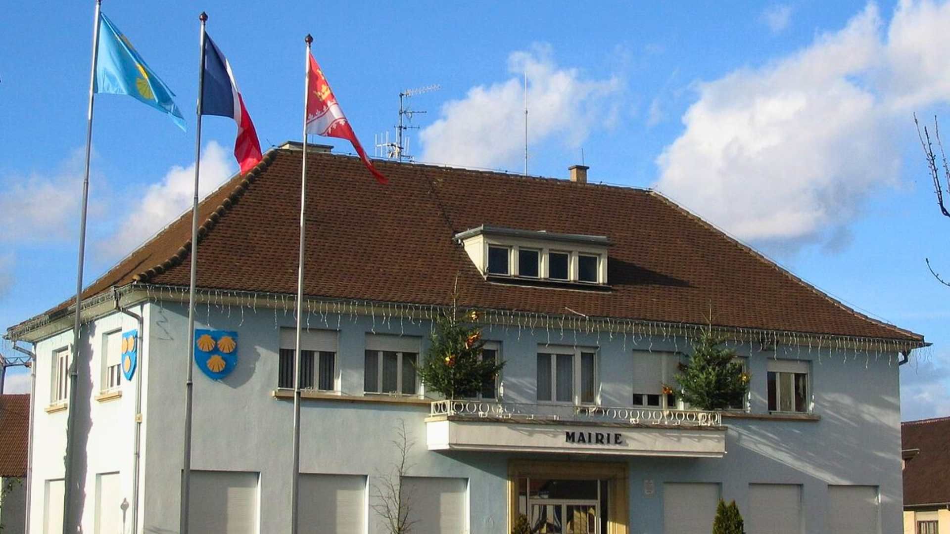 Hôtel de ville avec drapeaux ; ciel bleu.