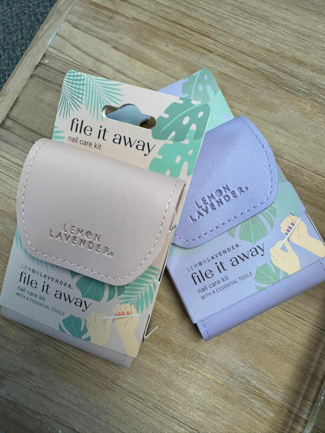 Two wallets are sitting on top of each other on a wooden table.