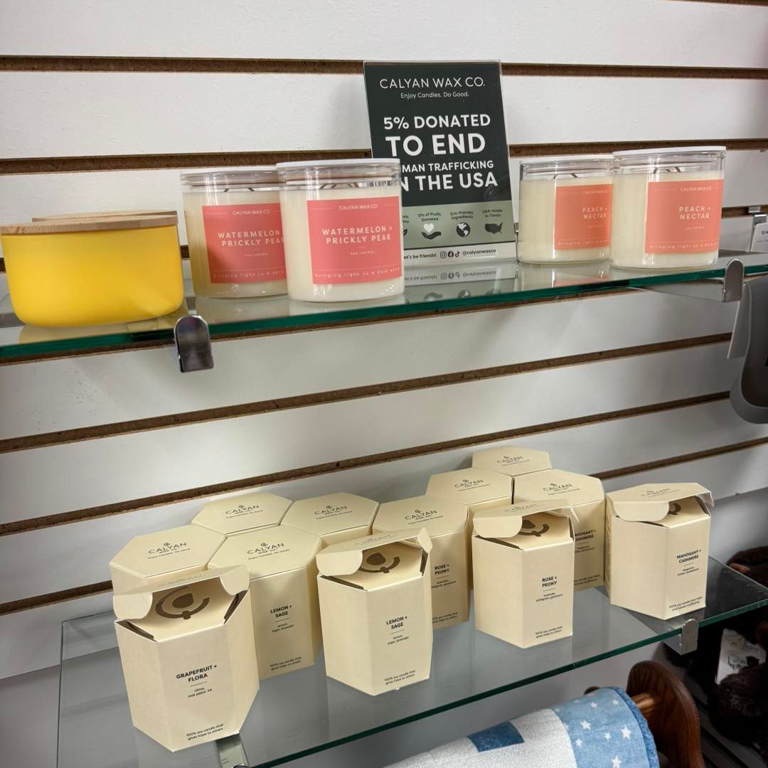 A shelf with candles and a sign that says 5% donated to end hunger in the usa
