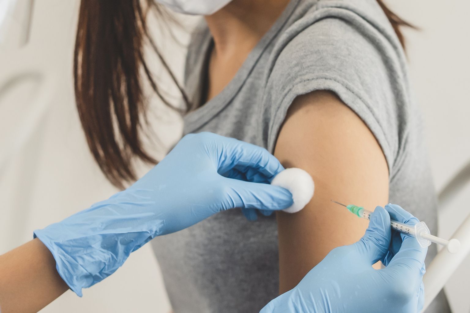 A woman is getting a vaccine in her arm.