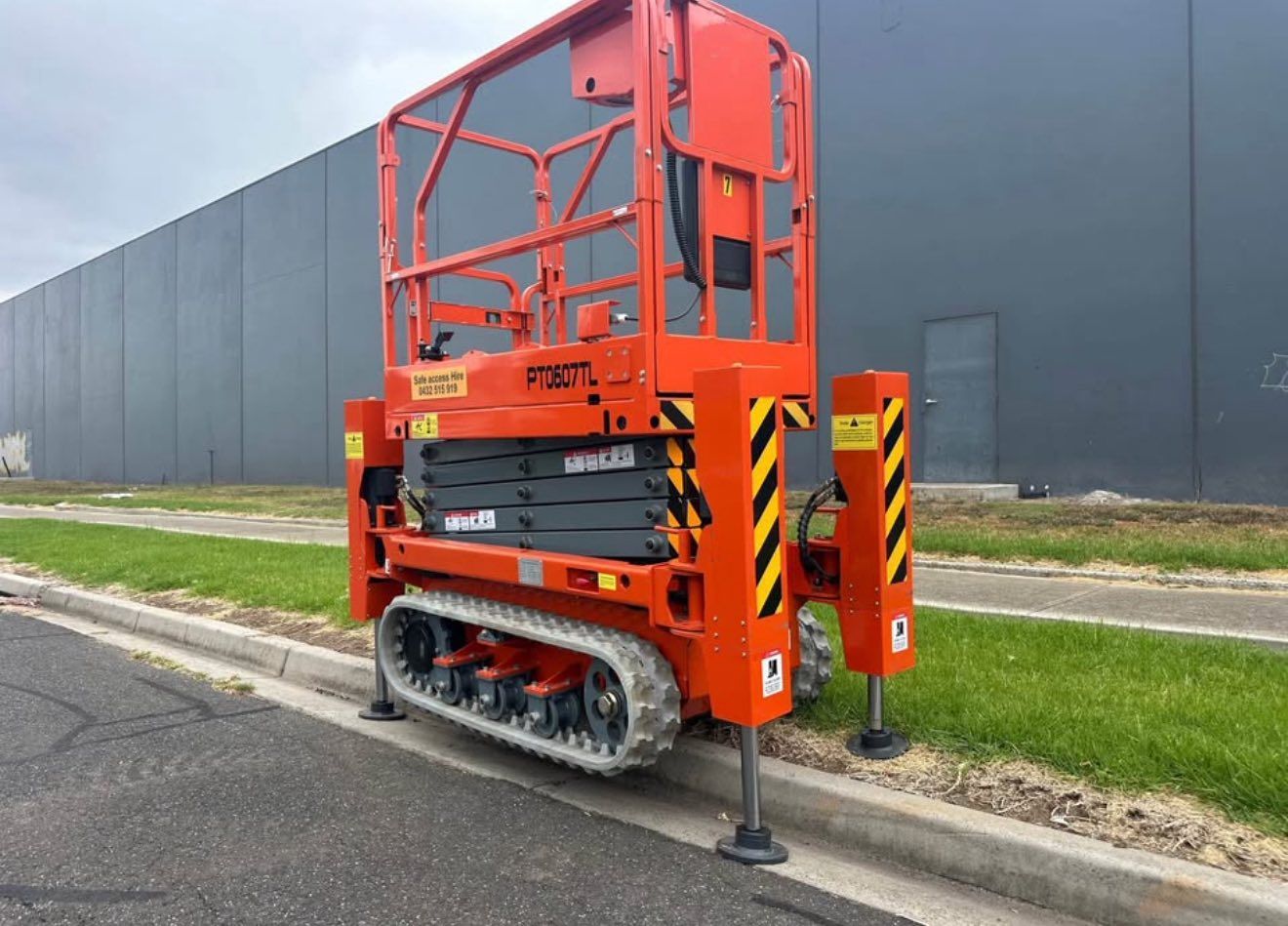 Construction site with scaffolding around a two-story building under construction, cloudy sky.