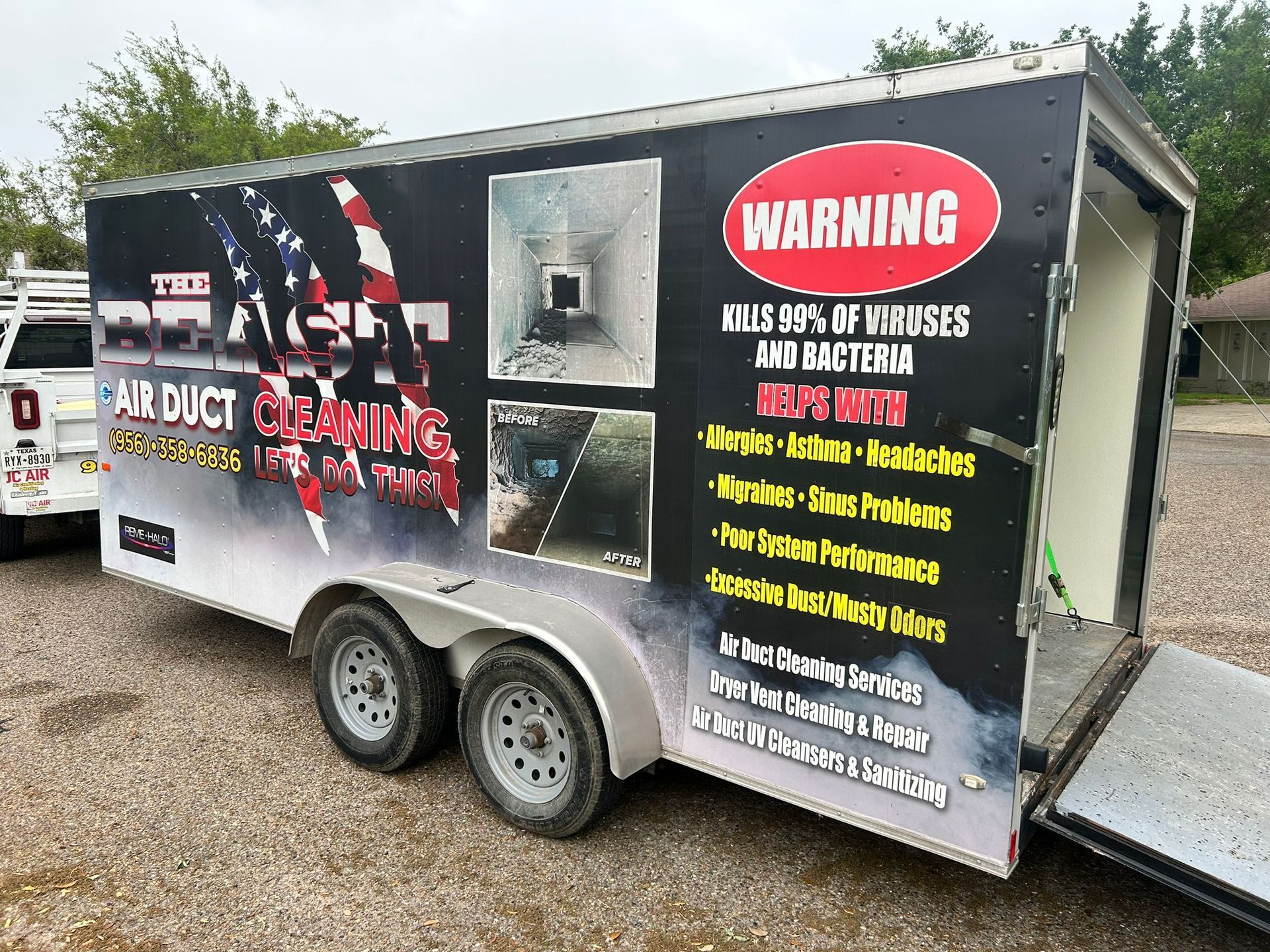 Air duct cleaning trailer with American flag graphic and open ramp.