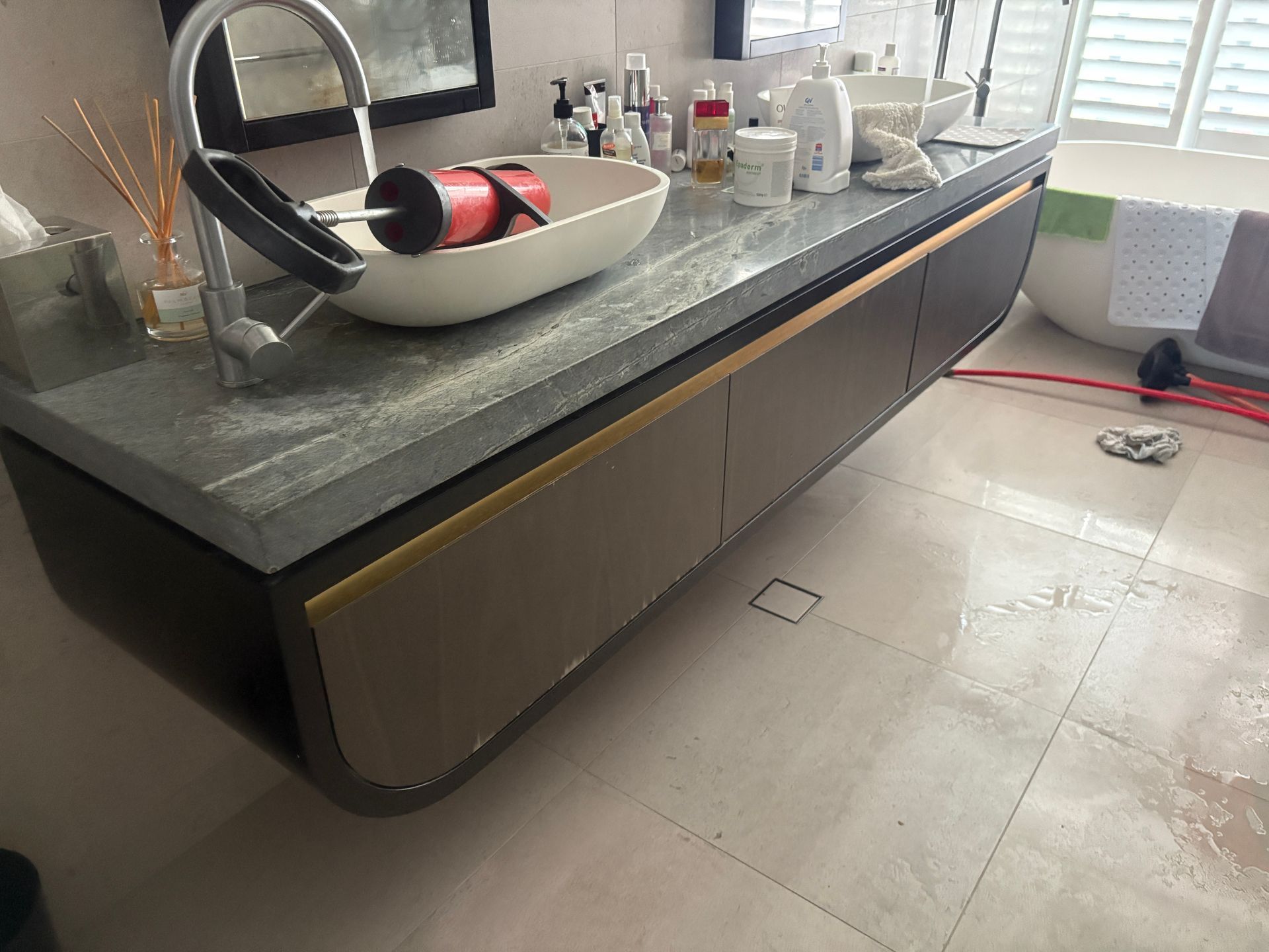 Bathroom vanity with a gray countertop, white sink, and brown cabinets.