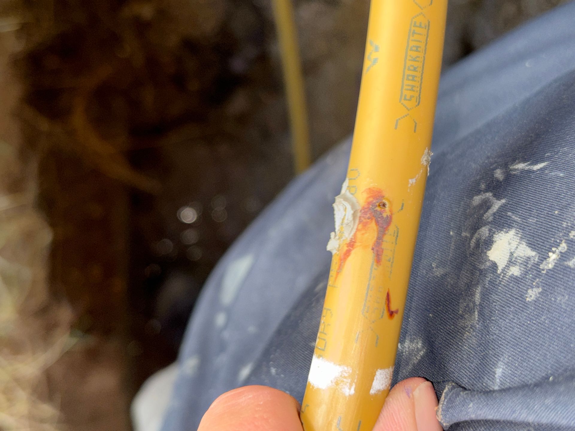 Hands in gloves installing a drain cover surrounded by cement and tile.