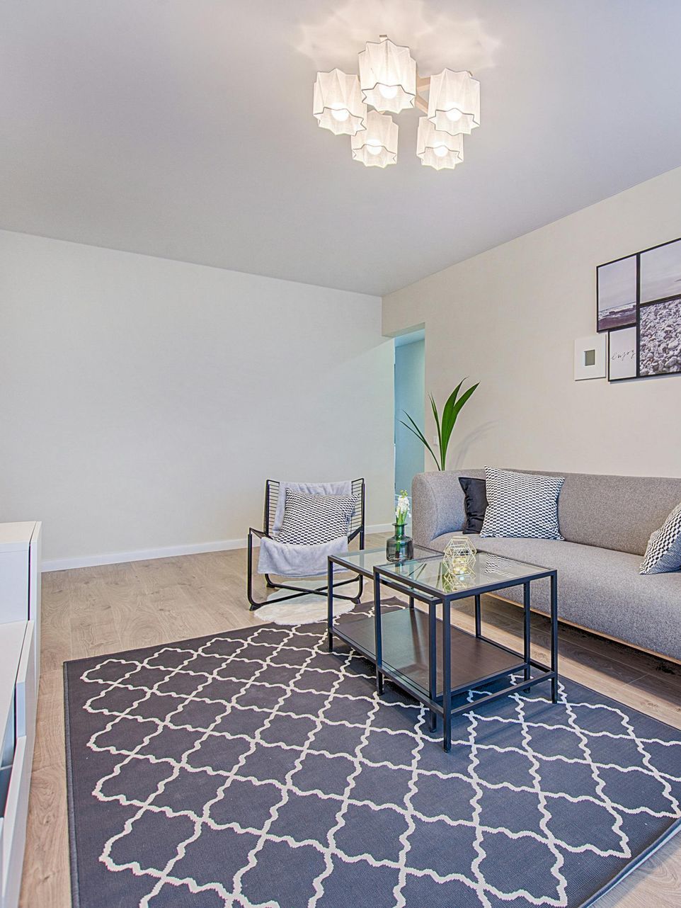 A clean living room with a couch , chair , coffee table and rug.
