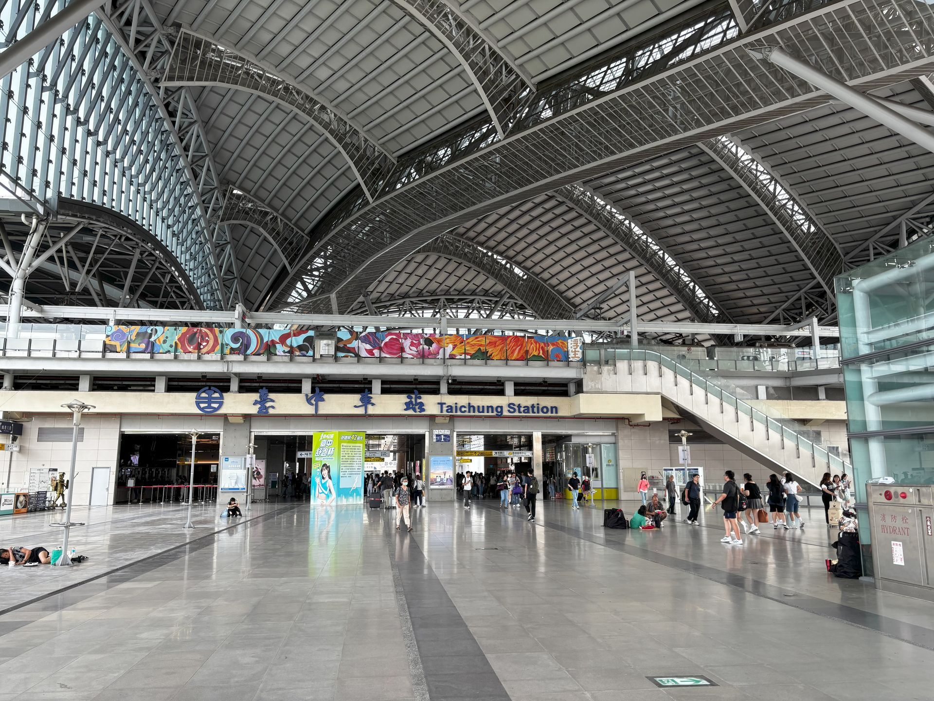 Taipei Main Station interior with people, arched roof, and entrance signage.