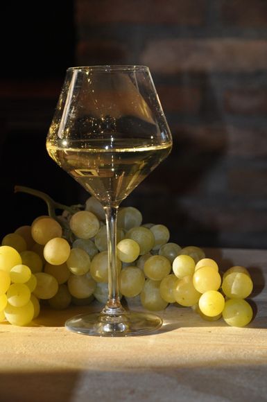 Calice di vino bianco con grappolo d'uva