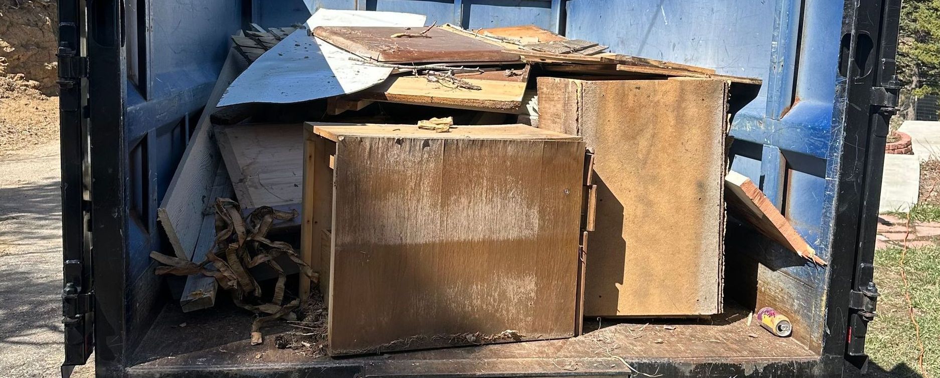 The back of a dump truck with a bunch of junk in it