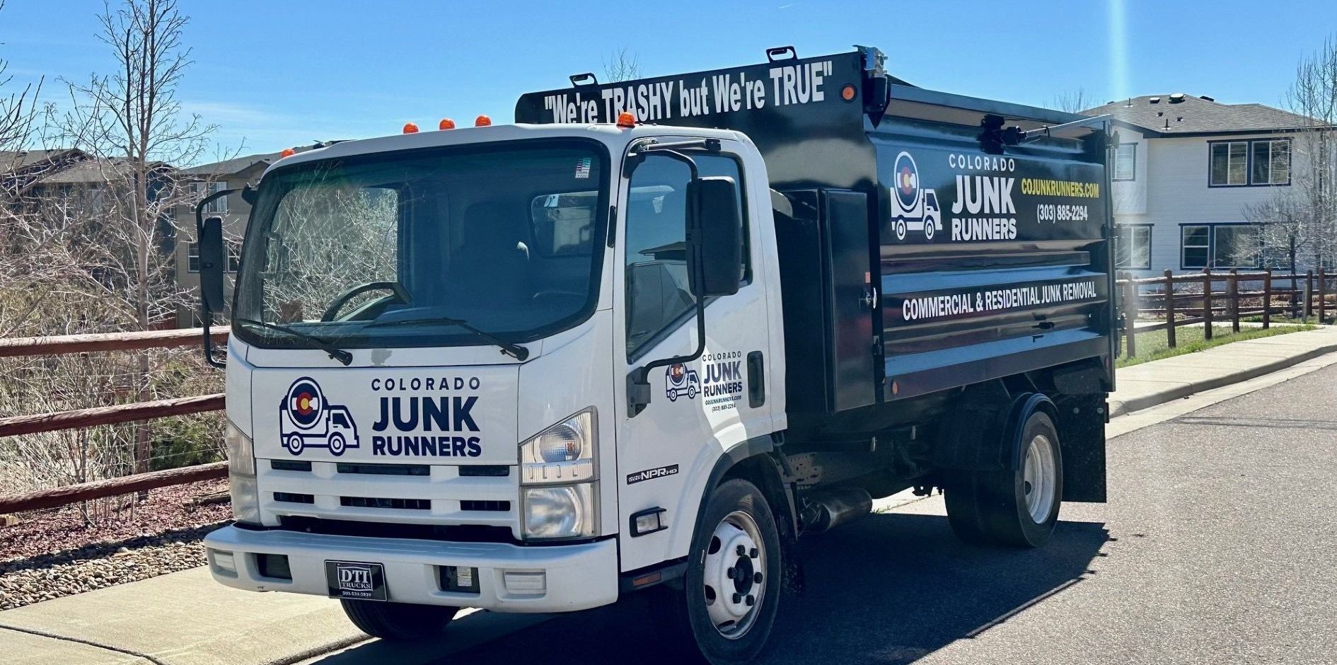 A junk truck is parked on the side of the road.