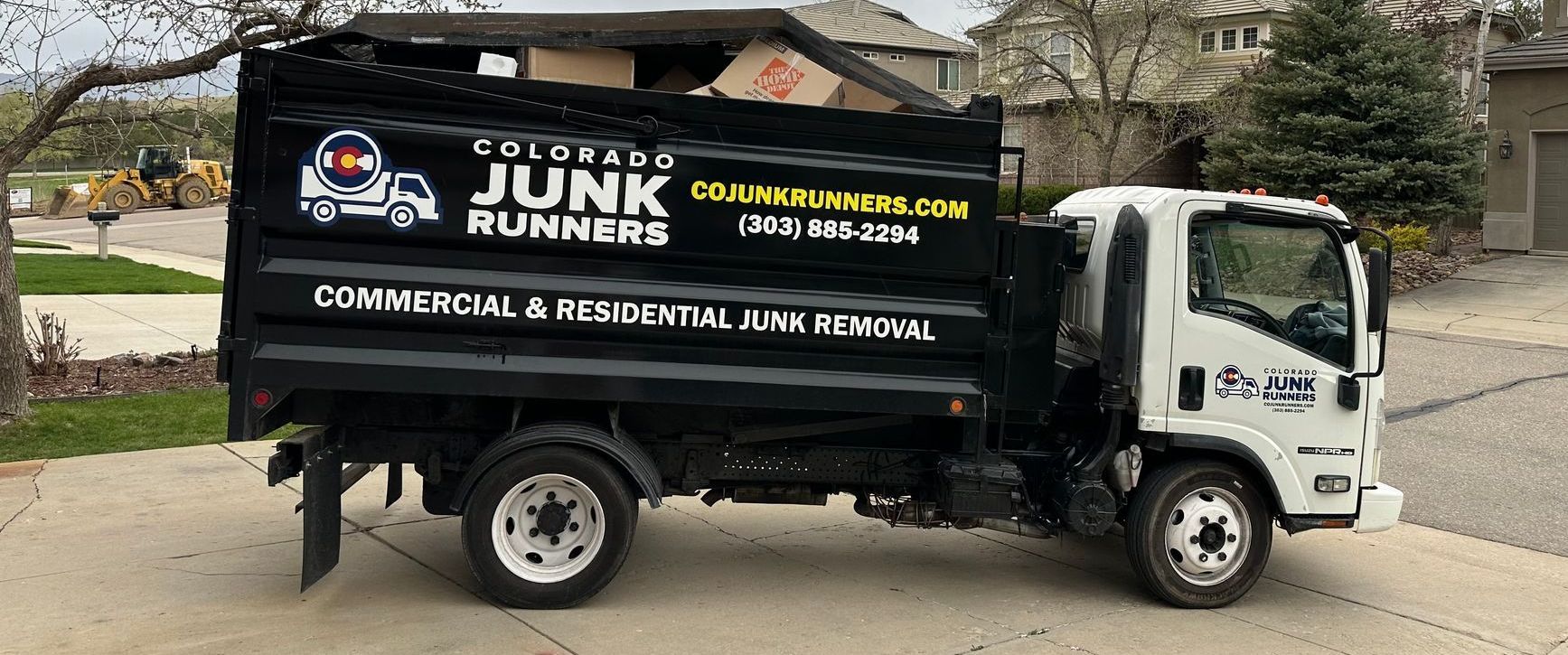 A junk runner truck is parked in front of a house.