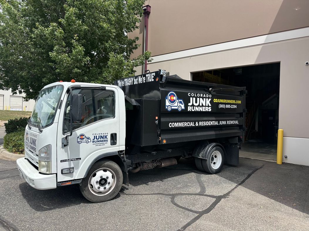 A Colorado Junk Runners truck parked in front of a building.