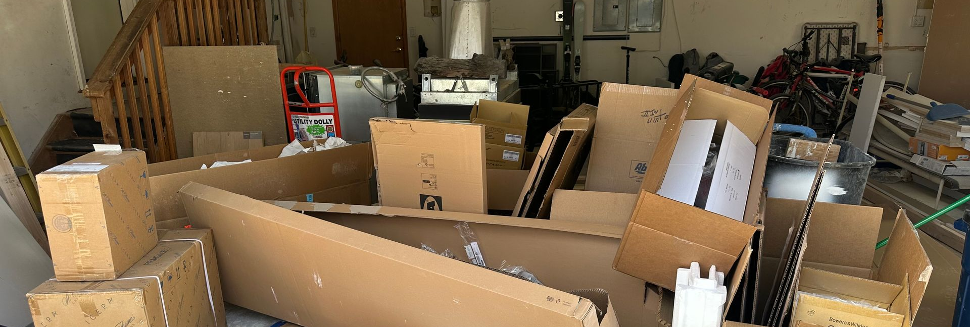 Cardboard boxes piled in a garage in Gunbarrel, Colorado ready to be removed professionally.